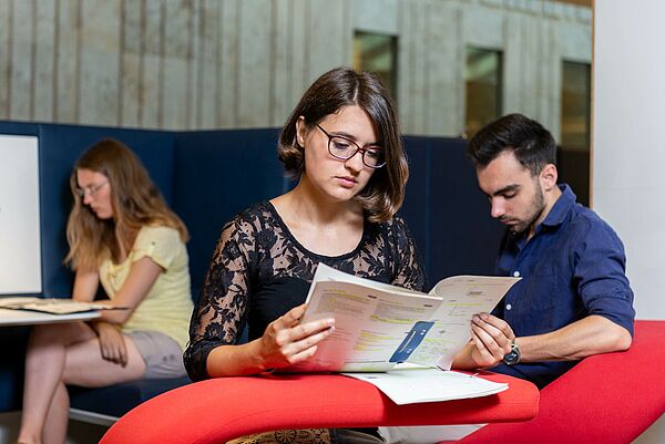 Drei Menschen im Gruppenarbeitsbereich der SLUB Zentralbibliothek, sitzend und lernend