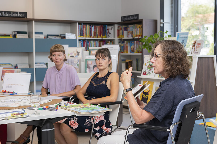 Drei Frauen an einem Tisch im Gespräch